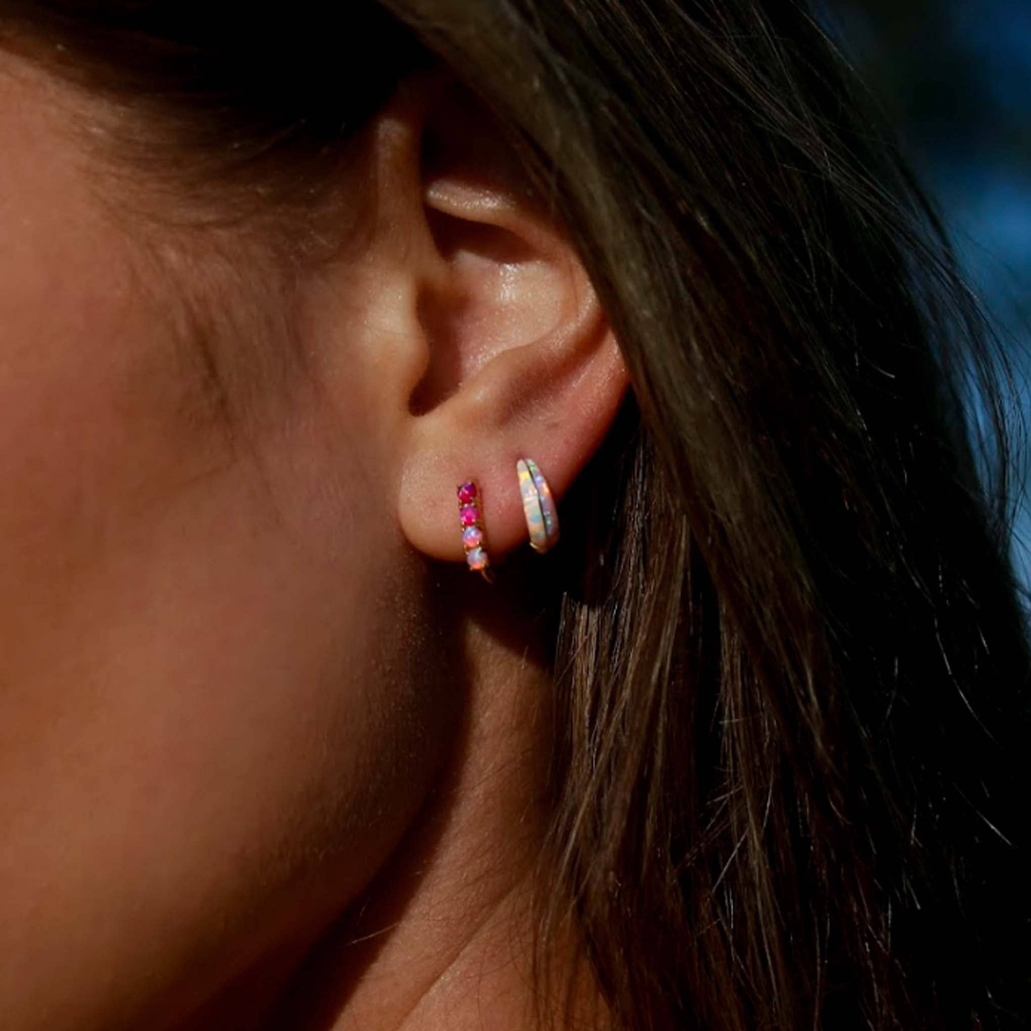 Close-up of an ear wearing two earrings with a blurred background