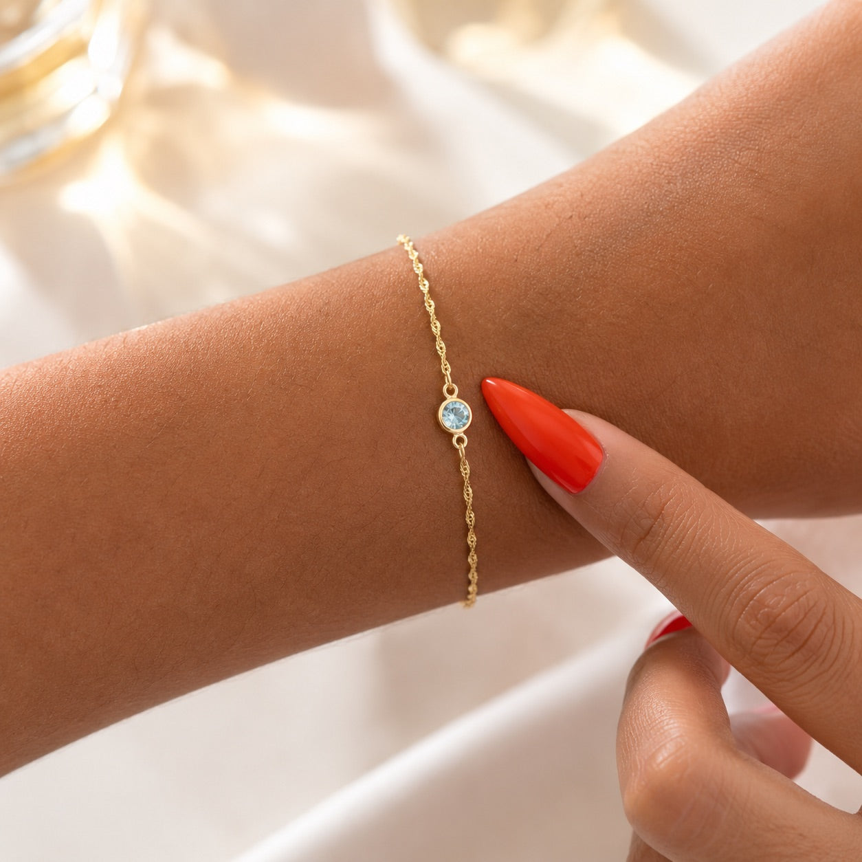 March birthstone gold jewelry charm. Light blue gemstone on a white background