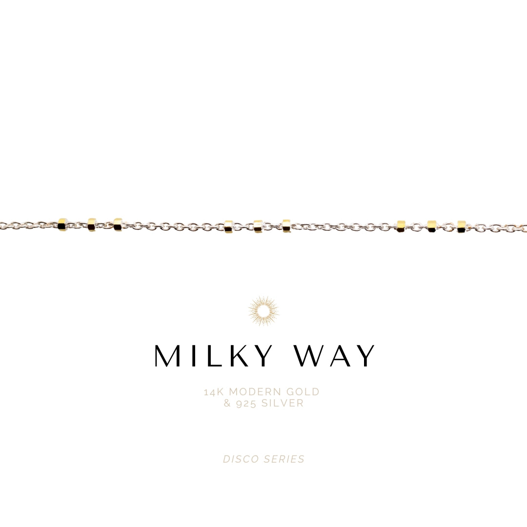 Necklace with gold and silver beads on a white background, featuring the brand 'Milky Way'.