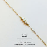 Gold permanent bracelet with opal stones on a white background, branded 'Opal Skies'.