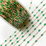 Gold chain with green beads on a white background