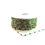 Gold chain with green beads on a white background