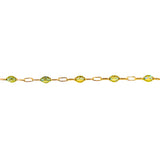 Gold bracelet with green gemstones on a white background