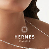 A close-up image of a bracelet with interlocked silver chains against a light background.