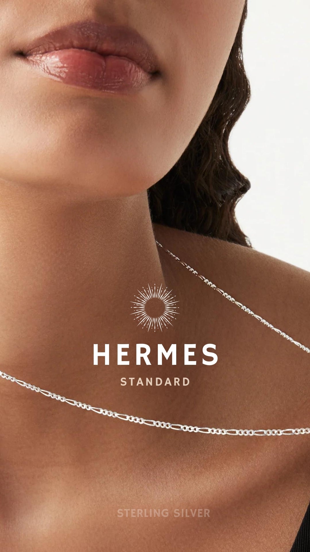 A close-up image of a bracelet with interlocked silver chains against a light background.